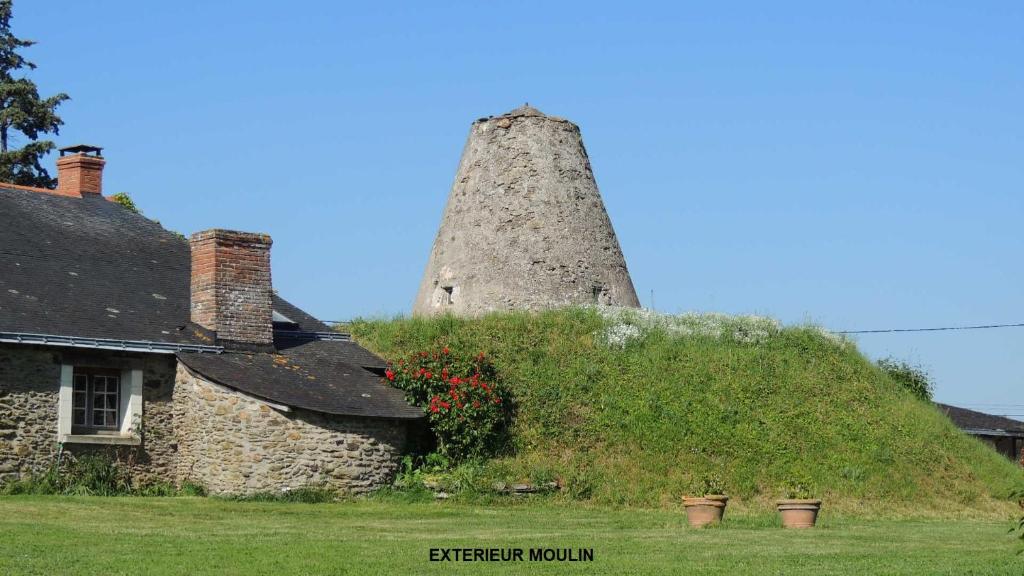 una vieja casa de piedra con una torre encima en Moulin de la Placette, en Faye-dʼAnjou