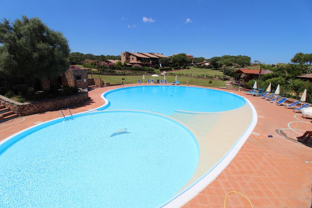 uma grande piscina com um golfinho no meio em Appartamenti residence Vela Blu Golfo Aranci em Marinella