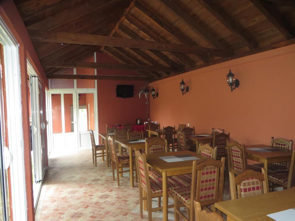 una sala da pranzo con tavoli e sedie in legno di Guest House Villa Živanović a Herceg-Novi