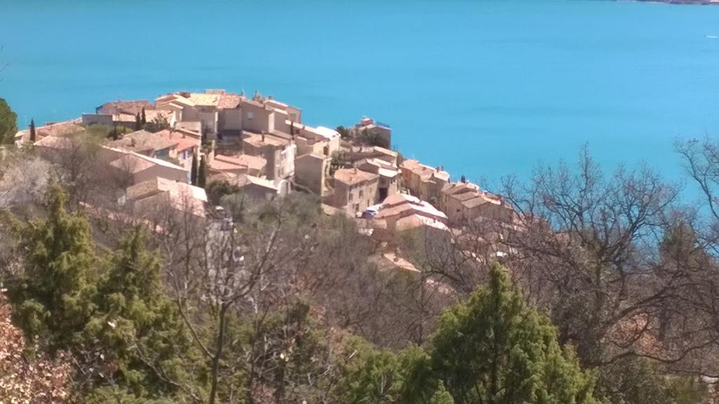 wioska na szczycie wzgórza z drzewami w obiekcie les Hauts du Lac w mieście Sainte-Croix-de-Verdon