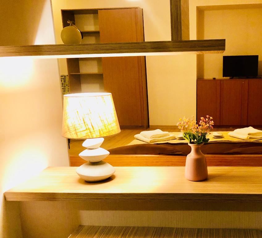 una lámpara y un jarrón sobre una mesa en una habitación en Holiday House en Tiflis