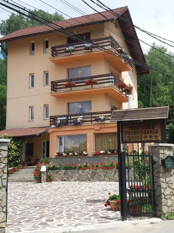 a building with a gate in front of it at Pensiunea Transilvania Lodge in Bran