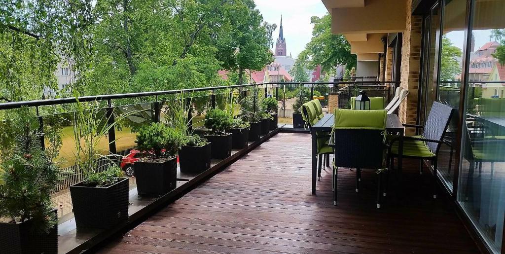 a balcony with a table and chairs and potted plants at GoPalanga in Palanga