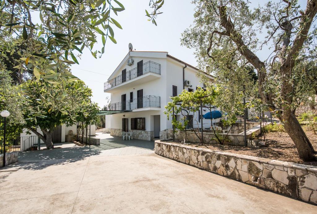 an exterior view of a white house with trees at Residenza Piccolo Uliveto in San Menaio