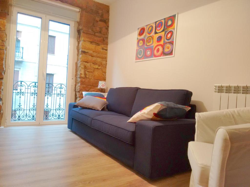 sala de estar con sofá azul y ventana en Heriz 8, en San Sebastián