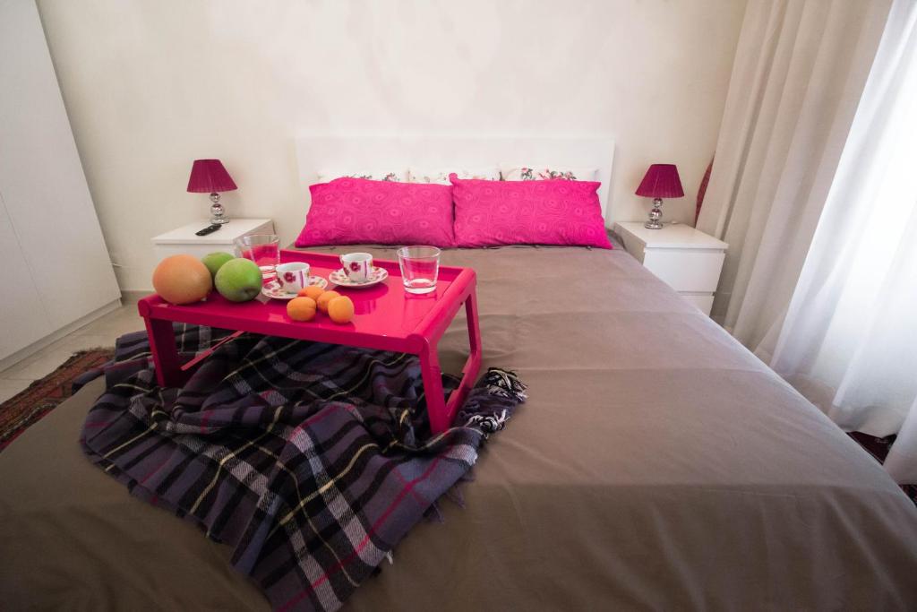 a bed with a red table with fruit on it at Asher's House Colosseum in Rome