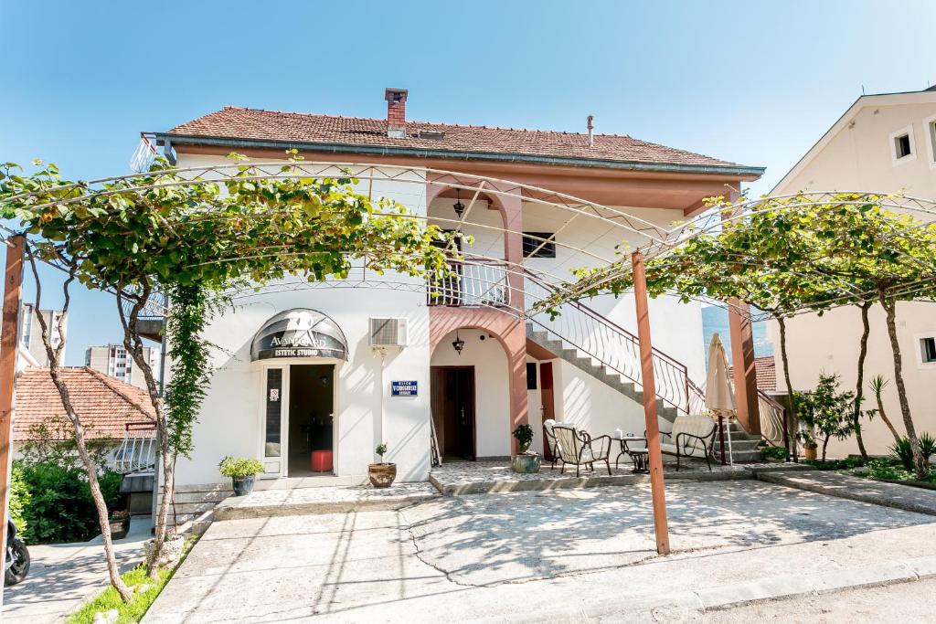 a white house with trees in front of it at Apartmani Pandurevic in Herceg-Novi