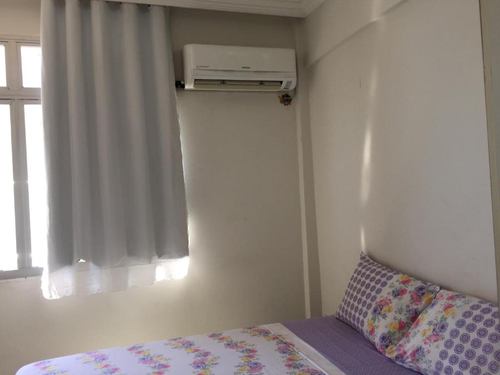 um pequeno quarto com uma cama e uma janela em Apartamento Studio 806 em Fortaleza