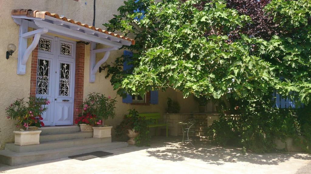 a house with a white door and a tree at Chambres et Tables d'Hotes "Au pres de ma Blonde" in Senouillac