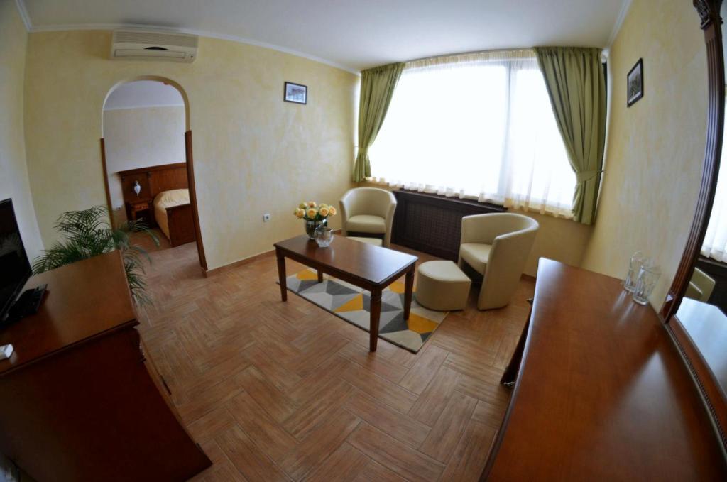 ein Wohnzimmer mit einem Tisch und Stühlen im Zimmer in der Unterkunft Central West Hotel in Sofia