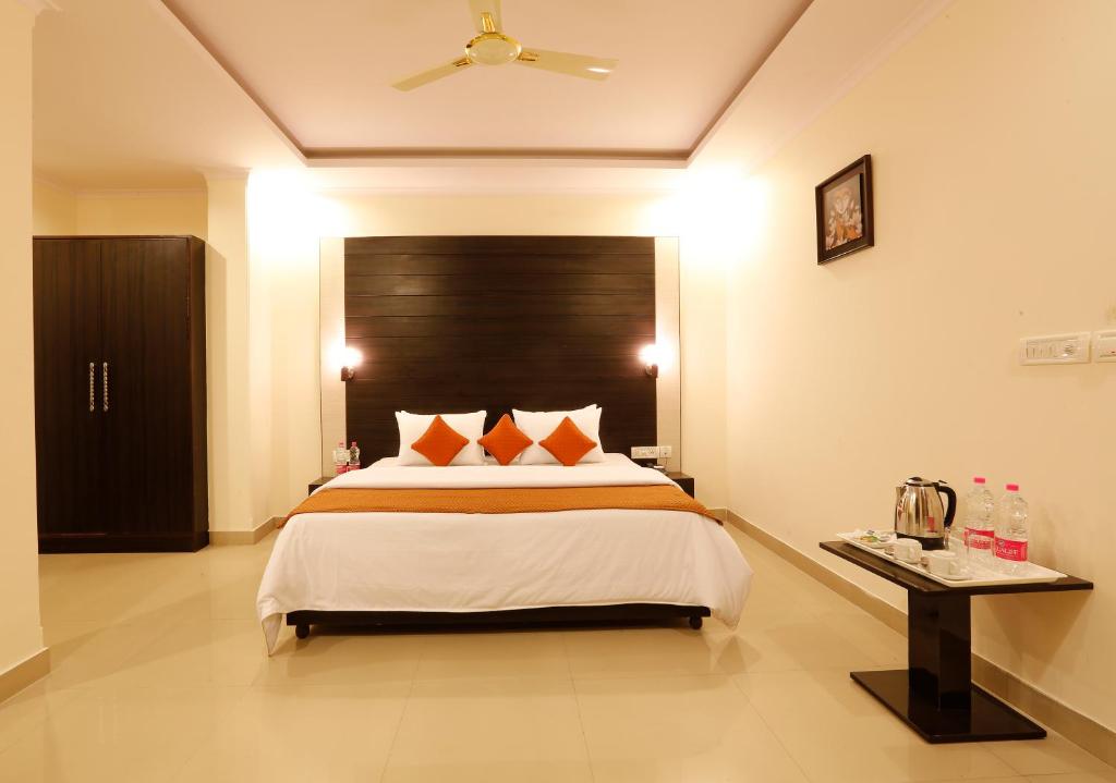 a bedroom with a large bed and a table at Hotel Chanakya inn in New Delhi