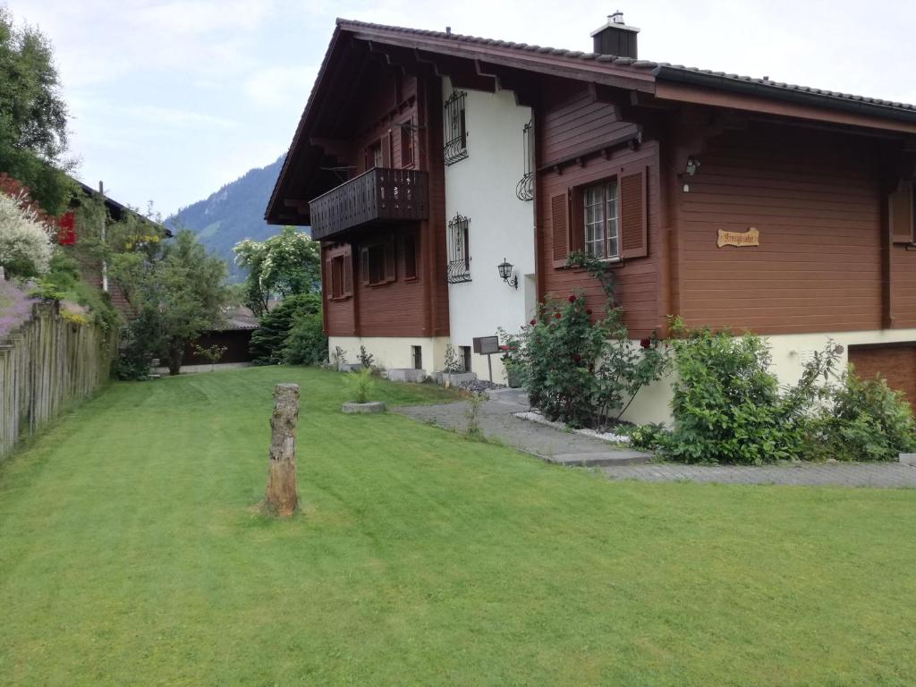 a house with a green lawn in front of it at Apartmenthaus Kreuzbuche in Flühli