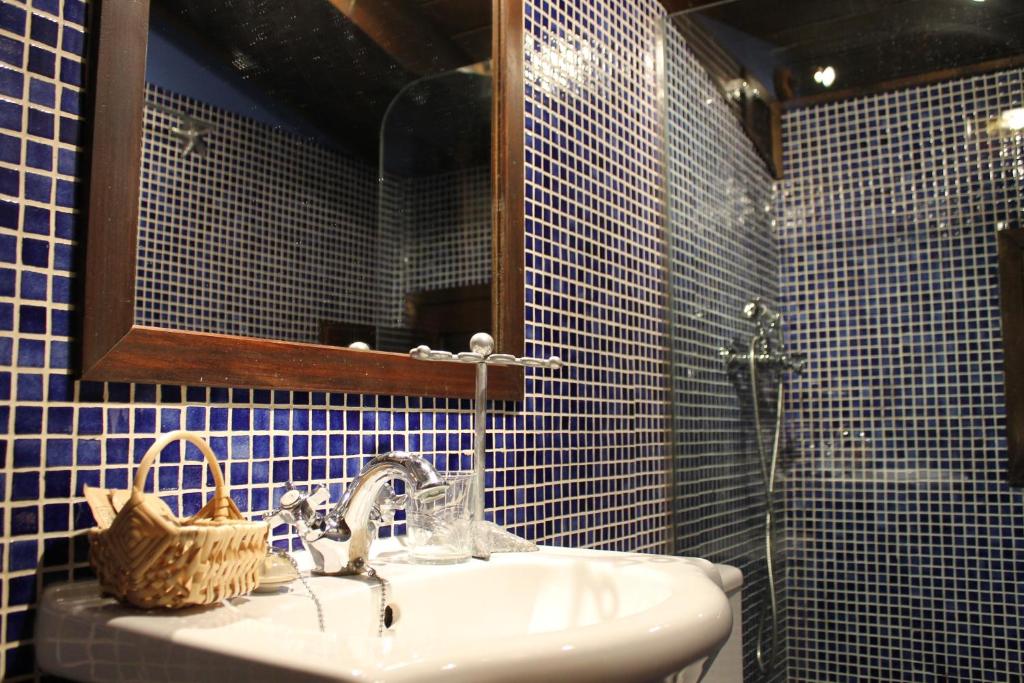 a bathroom with a sink and a mirror at Rodiles Rural Apartamentos in Selorio