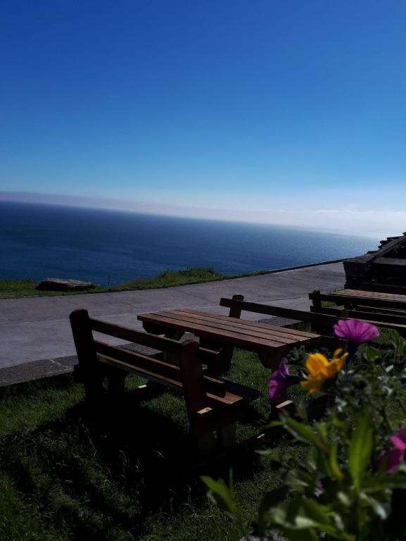 a wooden picnic table with a view of the ocean at Old Irish farmhouse in Dingle