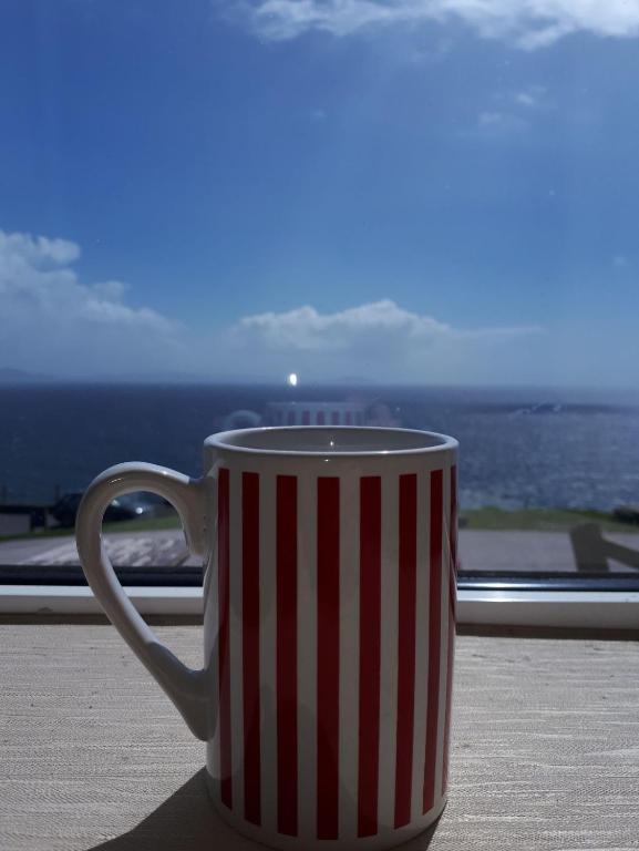 a red and white striped coffee cup sitting on a table at Old Irish farmhouse in Dingle