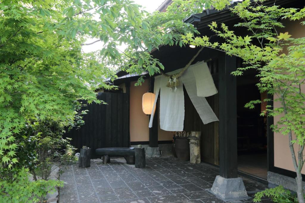 a garden with clothes hanging from a building at Shinwaen in Aso