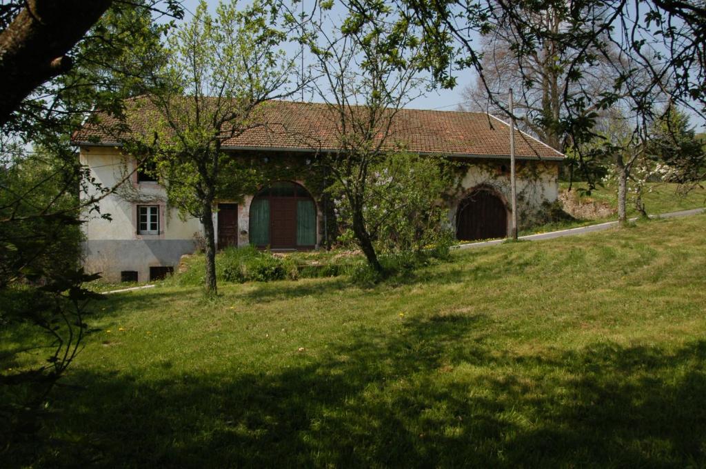 una casa en un campo de hierba con árboles delante en s'YVOUX plaît, en La Chapelle