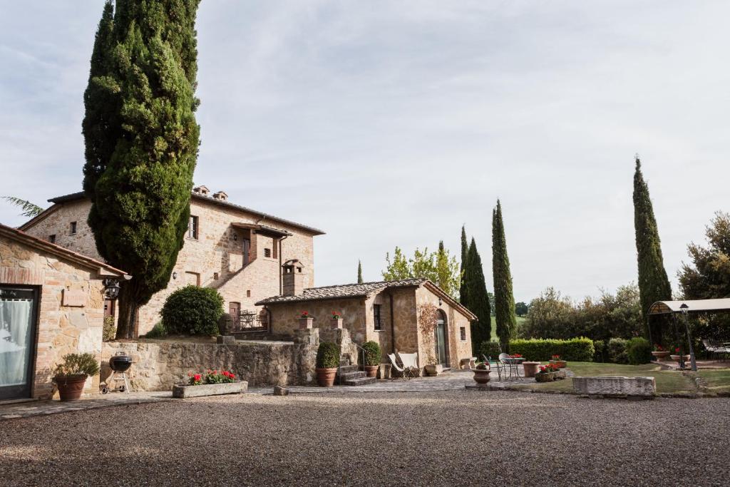 une maison avec des arbres en face d'une allée. dans l'établissement Montorio, à Montepulciano