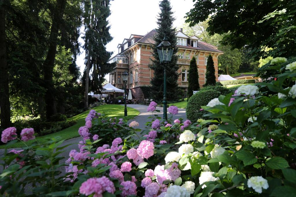 a house with a garden of flowers in front of it at Villa Hammerschmiede in Söllingen