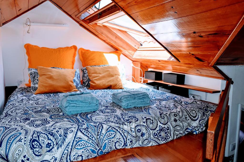 リスボンにあるBelem Mezzanineの木製天井の小さな部屋のベッド1台分です。