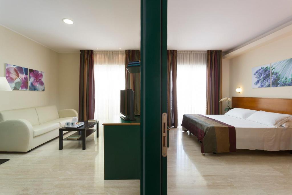 Postel nebo postele na pokoji v ubytování Astoria Suite Hotel