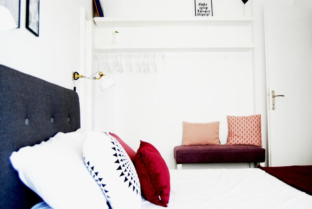 een slaapkamer met een wit bed met rode kussens bij Beach Side Apart I in Kavala