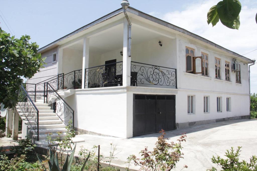 ein weißes Haus mit einer Treppe davor in der Unterkunft House Magda in Batumi