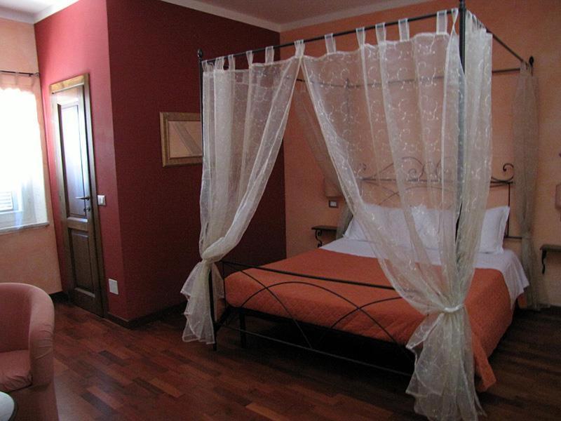 ein Schlafzimmer mit einem Himmelbett in der Unterkunft La Luna nel Borgo in Spello