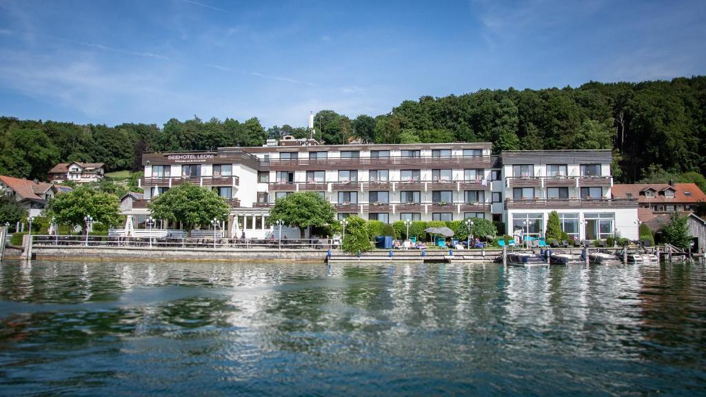 a row of houses in front of a river at Seehotel Leoni in Berg am Starnberger See