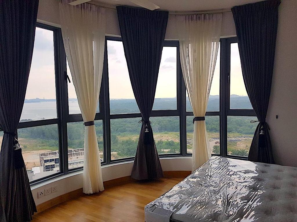a room with large windows with a bed in front at Johor Malaysia Teega Suites@ Puteri Harbour Condo 4607 Persiaran Lasamana , Teega Suites in Nusajaya