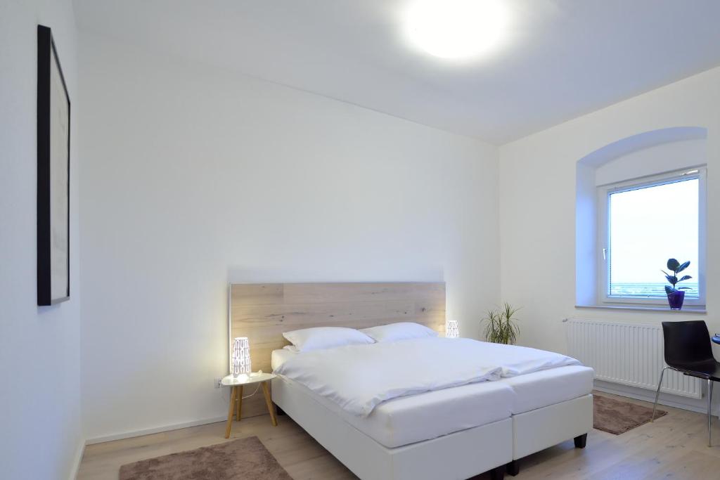 エンスにあるBastei Apartment Ennsの白いベッドルーム(白いベッド1台、窓付)