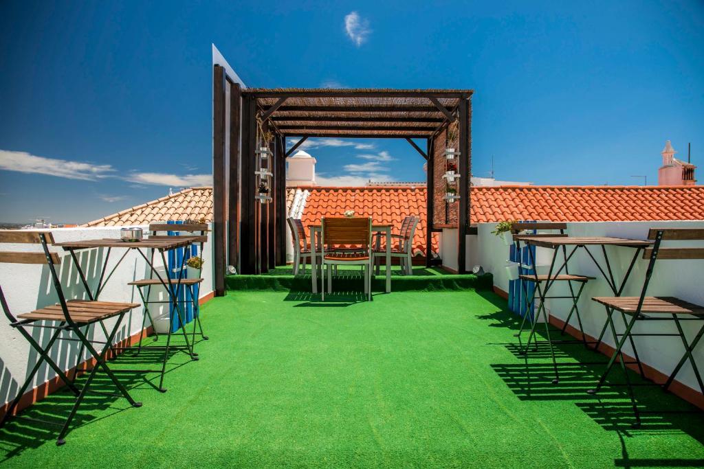 a balcony with green flooring and tables and chairs at Blue Door Lagos in Lagos