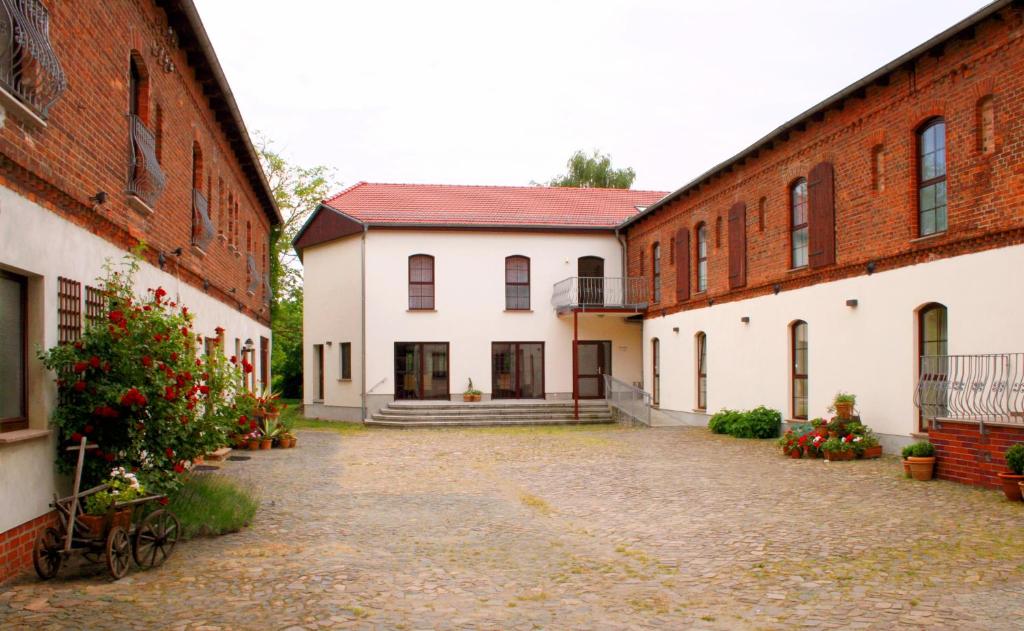 eine Reihe von Backsteingebäuden mit einem Innenhof in der Unterkunft Landhaus Heinrichshof in Jüterbog