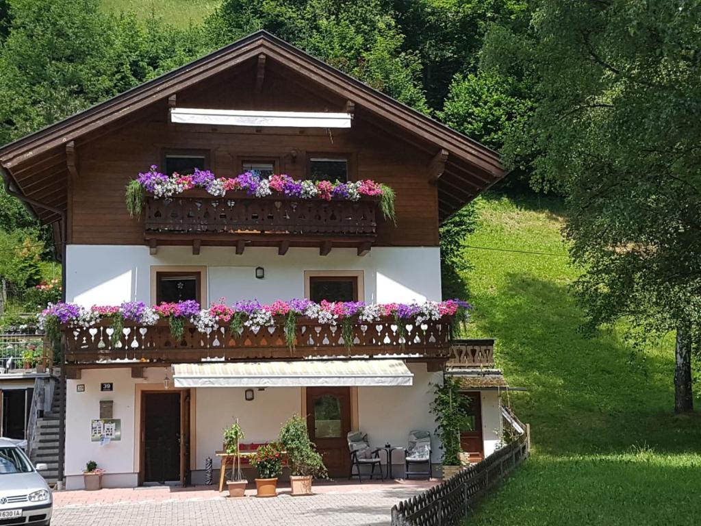 ein Haus mit einem Balkon mit Blumen darauf in der Unterkunft Haus Gandler in Zell am See