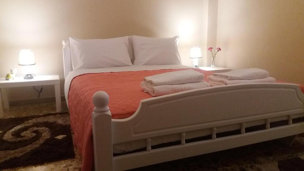 een slaapkamer met een wit bed en handdoeken bij Crystal Home near Airport in Artemida