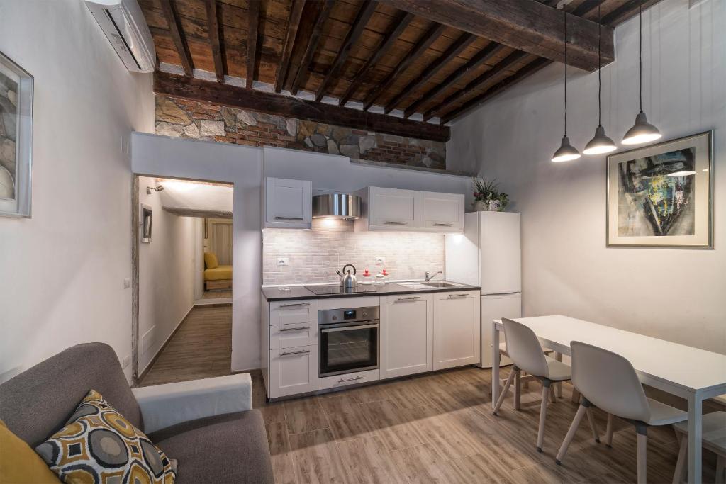 eine Küche mit weißen Schränken sowie einem Tisch und Stühlen in der Unterkunft Guelfa House in Florenz