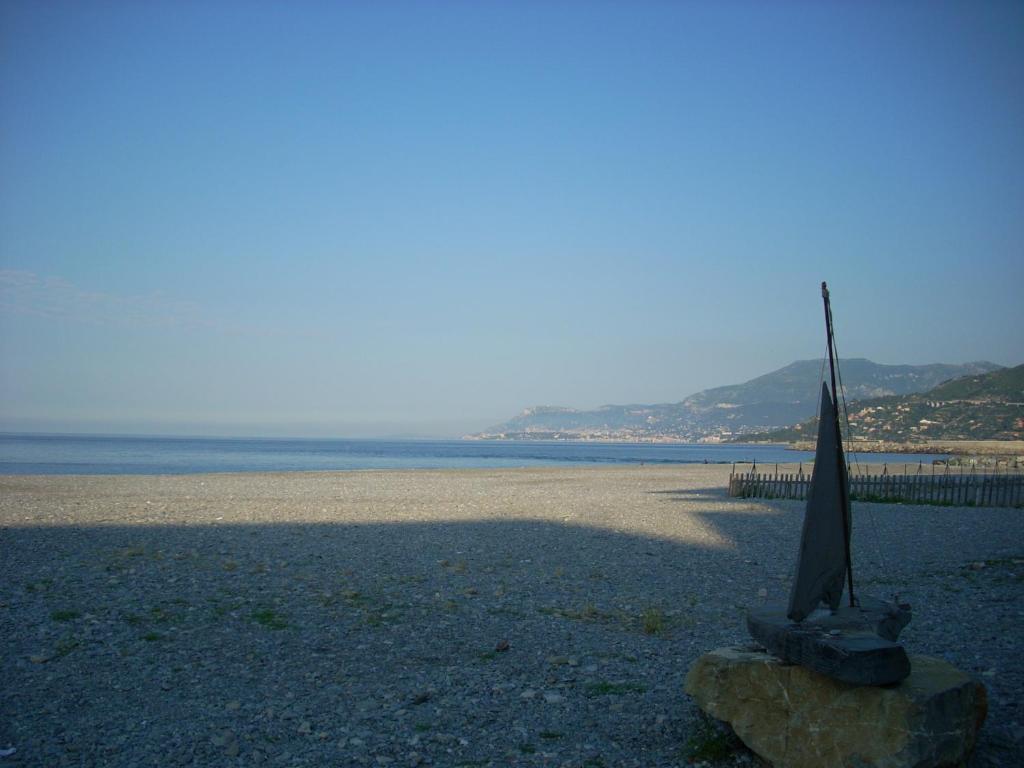 uma estátua numa praia com o oceano ao fundo em Appartamento al mare di Ventimiglia em Ventimiglia