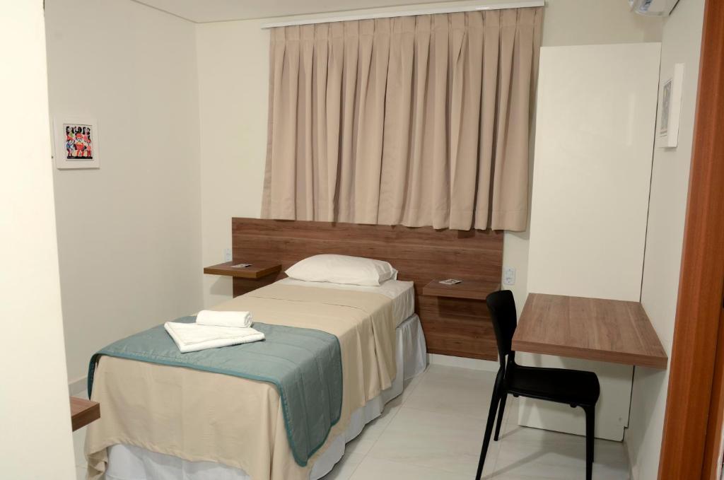 a bedroom with a bed and a desk at Asa Branca Hotel in Araripina