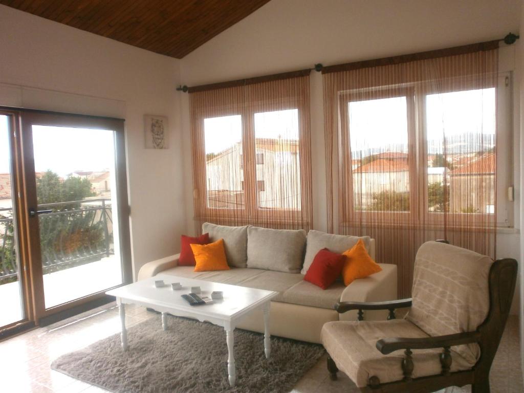 uma sala de estar com um sofá e uma mesa em Apartmani Ljubica em Kaštela