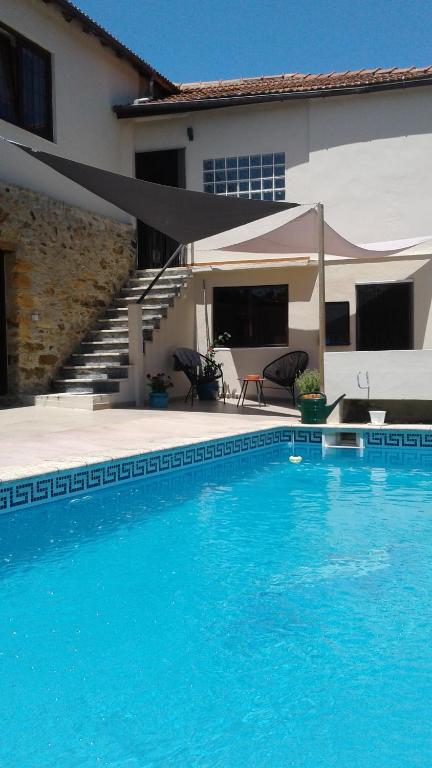 une grande piscine en face d'une maison dans l'établissement Casa de Coco, à Vila Nova de Poiares