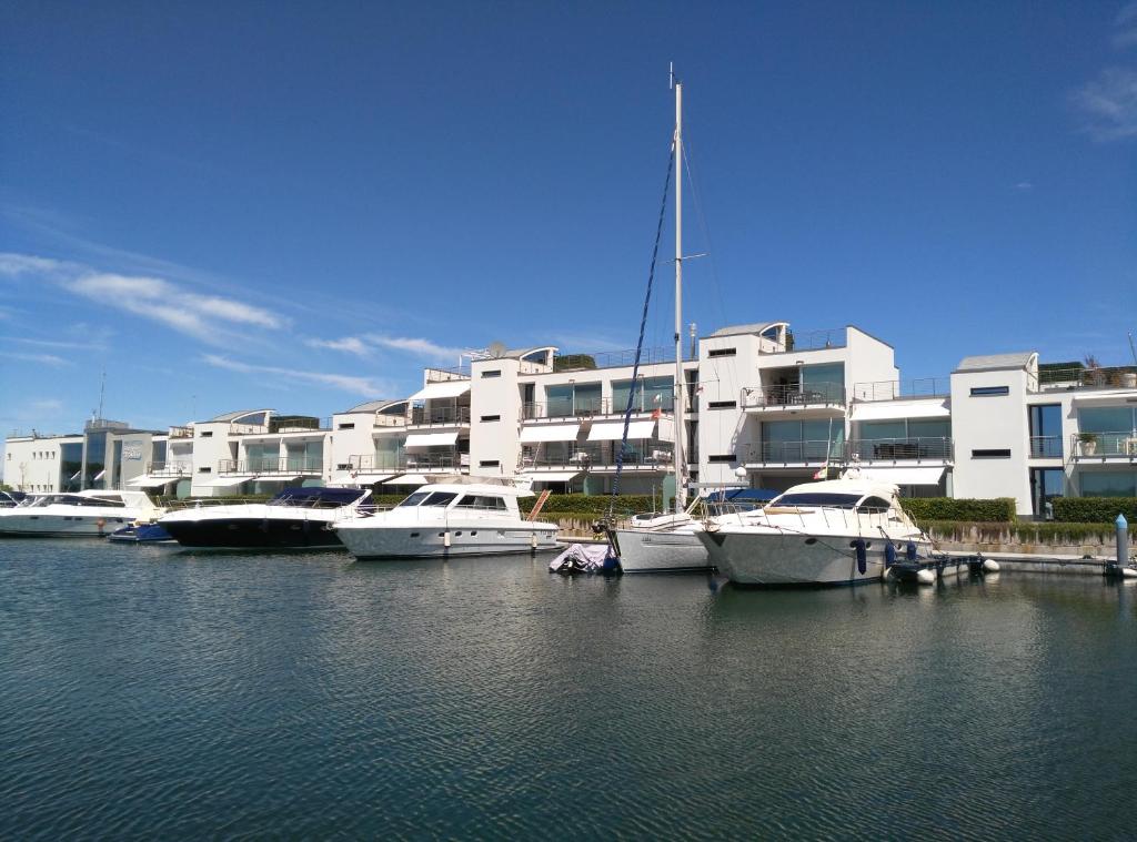 Apartment Mare e Laguna في ليدو دي يسولو: مجموعة من القوارب ترسو في الماء امام مبنى