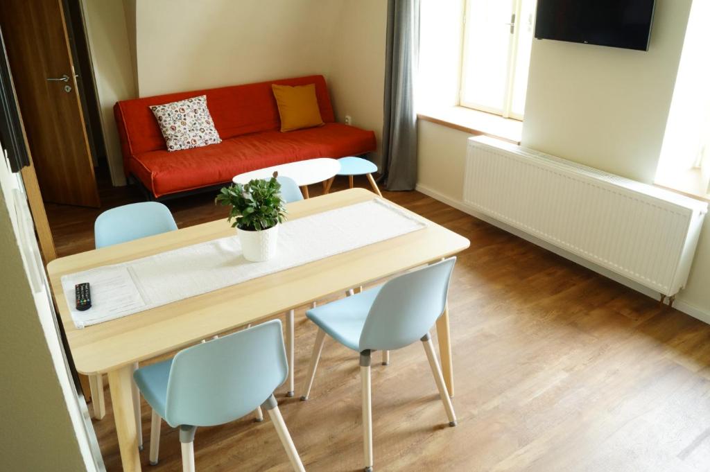 a living room with a red couch and a table and chairs at Apartmány u komína in Terezín