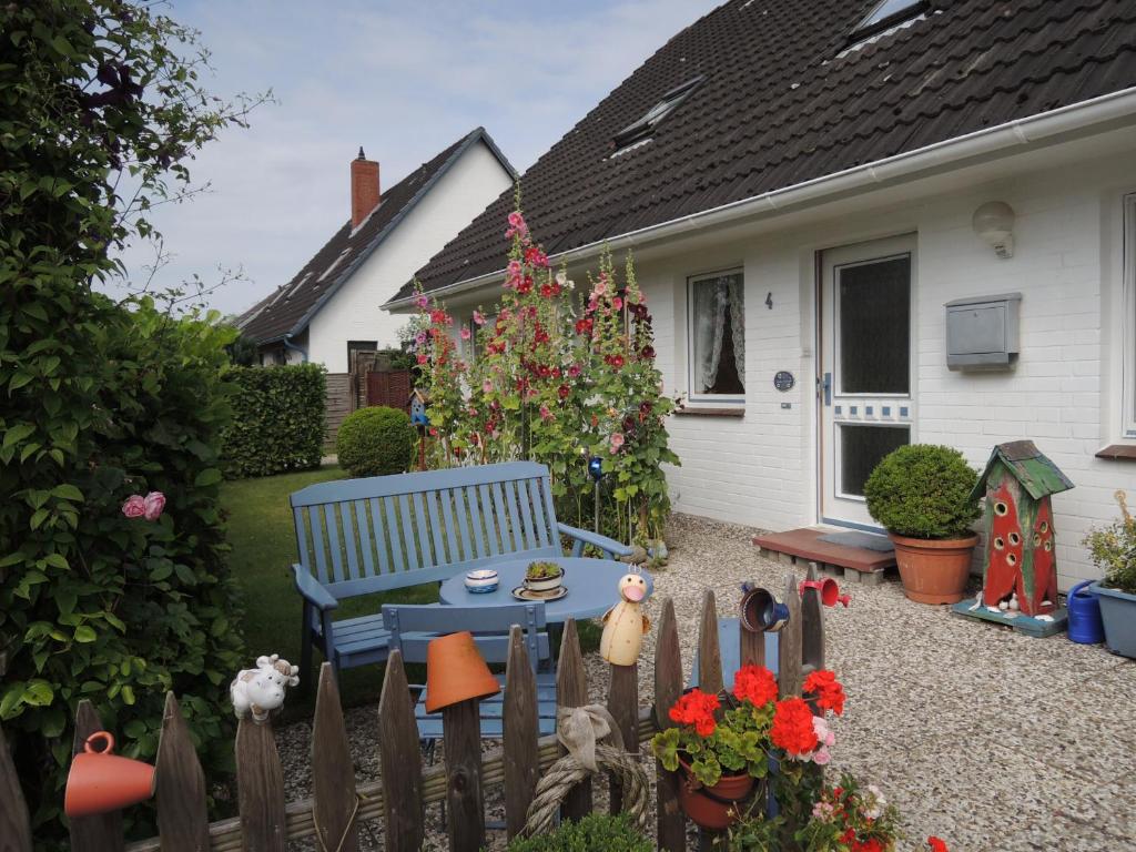 a garden with a blue bench in front of a house at Goden Wind 4 in Westerdeichstrich