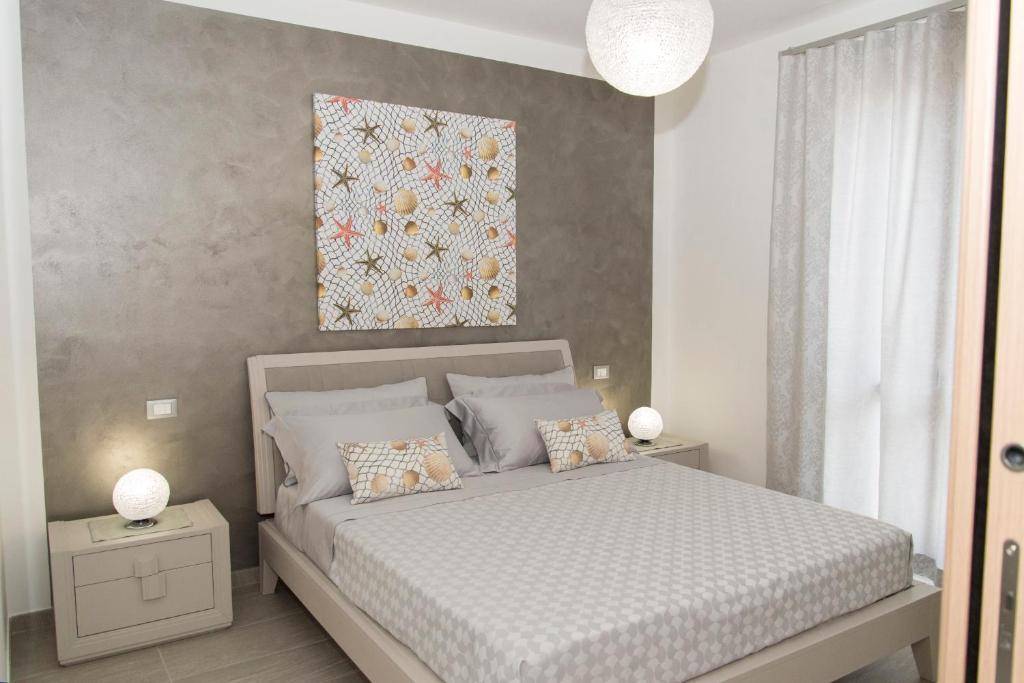 a bedroom with a bed and a painting on the wall at Casa Vacanze Fontana in San Vito lo Capo