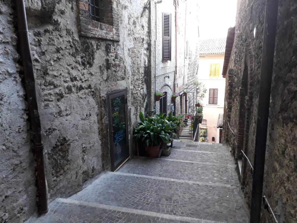 un callejón en un viejo edificio con una puerta y una planta en Nonna Bruna en Rieti