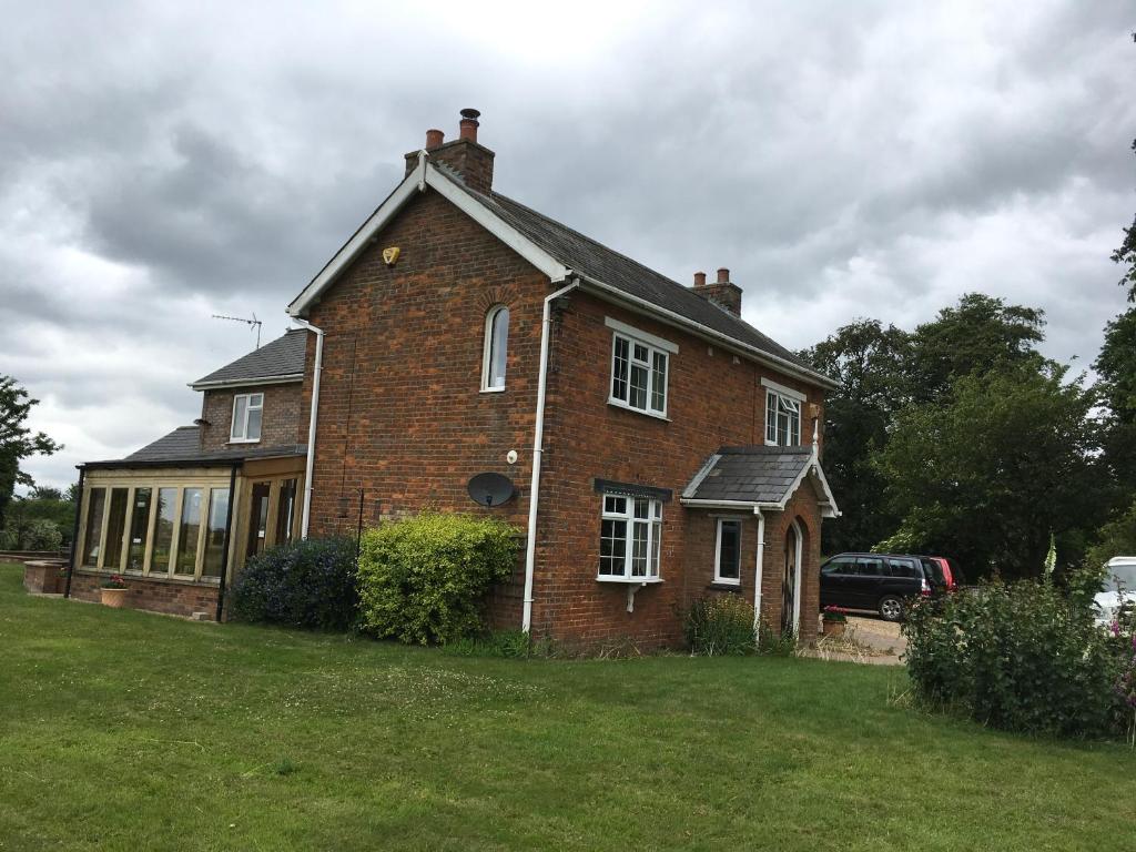 a brick house with a car parked in front of it at St Mary’s Lodge B and B in King's Lynn