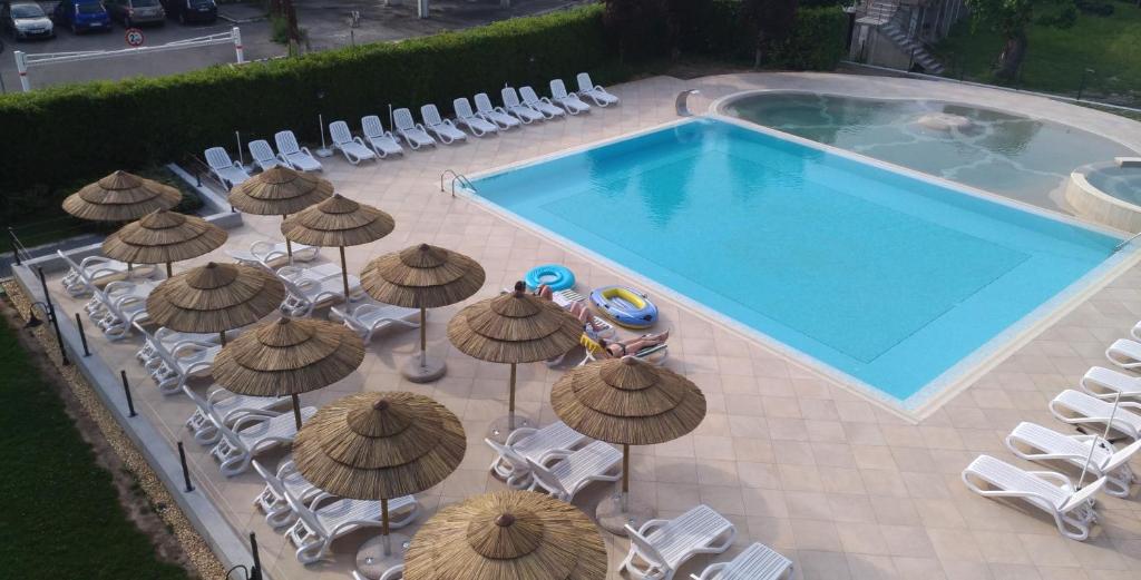 een uitzicht over een zwembad met parasols en stoelen bij Nettuno Residence Hotel in Peschiera del Garda