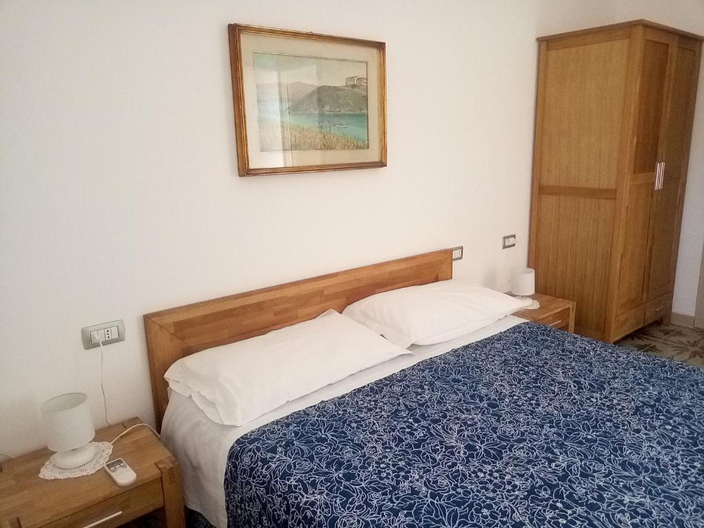 ein Schlafzimmer mit einem Bett und einem Bild an der Wand in der Unterkunft I tre scalini in Stintino