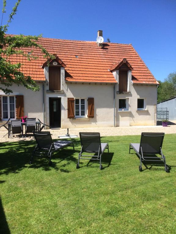 a group of chairs sitting in the grass in front of a house at GITE DE FRANCE "A l'essentiel" in Sidiailles