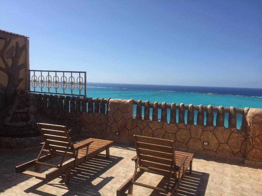 a group of chairs sitting next to a stone wall at Al-Madina Tower Apartments in Marsa Matruh